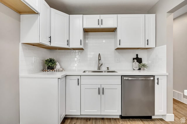 8689 W Edith Dr, Magna, UT 84044 - kitchen featuring stainless steel dishwasher, a sink, light countertops, light wood-type flooring, and white cabinetry