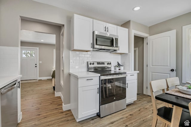 8689 W Edith Dr, Magna, UT 84044 - kitchen featuring stainless steel appliances, light wood-style flooring, light countertops, white cabinets, and recessed lighting