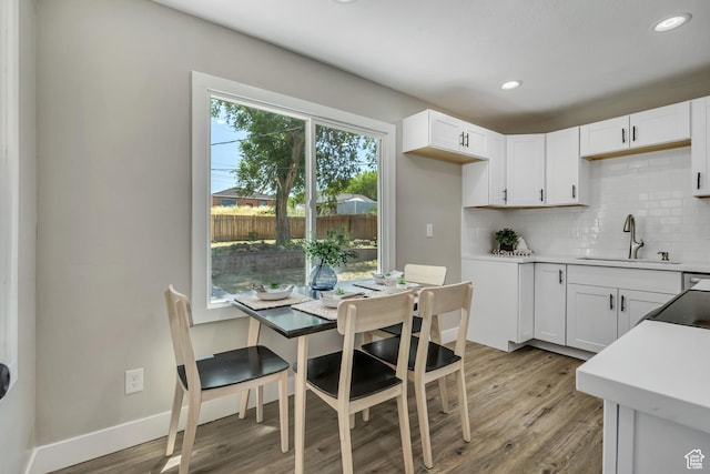 8689 W Edith Dr, Magna, UT 84044 - kitchen featuring a sink, backsplash, light wood-type flooring, white cabinets, and recessed lighting