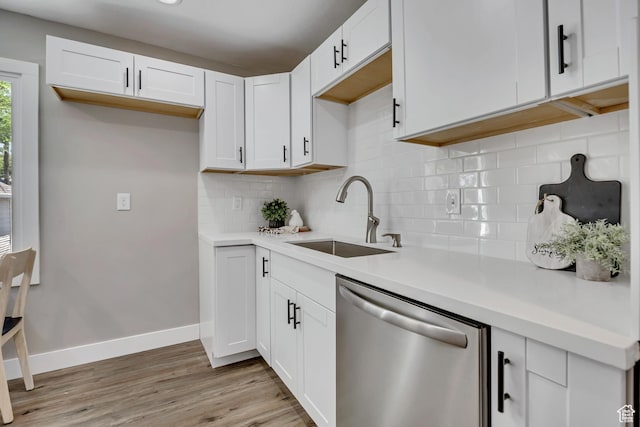8689 W Edith Dr, Magna, UT 84044 - kitchen featuring dishwasher, a sink, light wood-style flooring, tasteful backsplash, and white cabinets