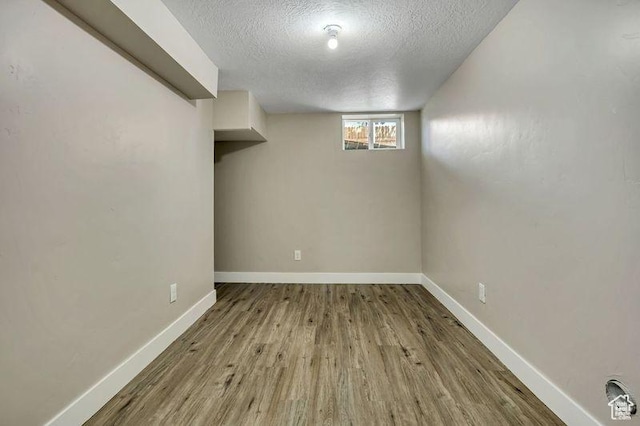 8689 W Edith Dr, Magna, UT 84044 - basement with a textured ceiling, wood finished floors, and baseboards