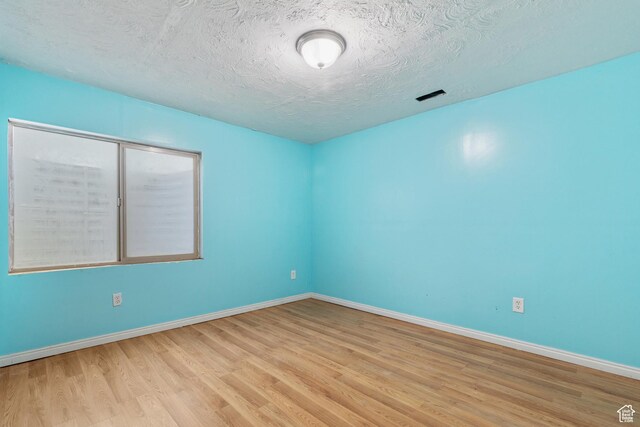 2271 W Pointe Meadow Dr N, Lehi, UT 84043 - empty room with wood finished floors, baseboards, and a textured ceiling