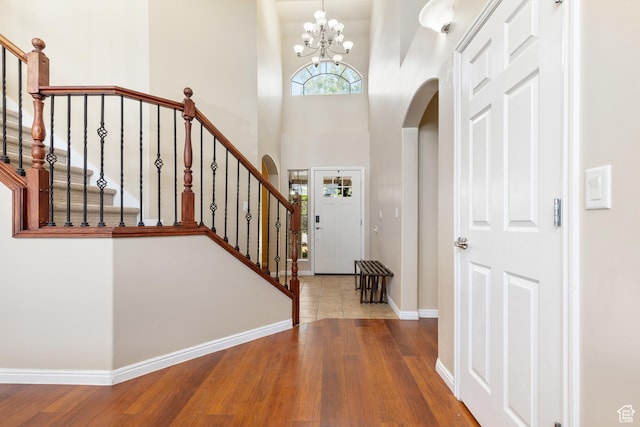 2271 W Pointe Meadow Dr N, Lehi, UT 84043 - entryway featuring arched walkways, wood finished floors, stairway, a chandelier, and a high ceiling