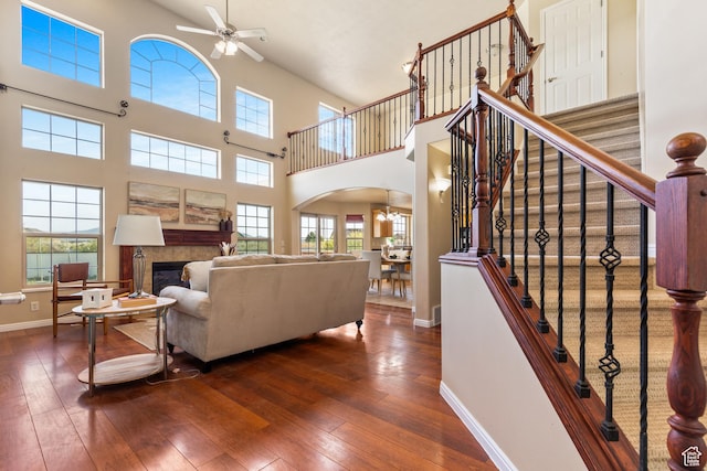 2271 W Pointe Meadow Dr N, Lehi, UT 84043 - living room with arched walkways, ceiling fan, a towering ceiling, hardwood / wood-style floors, and baseboards