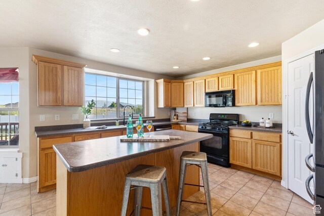2271 W Pointe Meadow Dr N, Lehi, UT 84043 - kitchen featuring black appliances, dark countertops, light tile patterned floors, a kitchen island, and recessed lighting