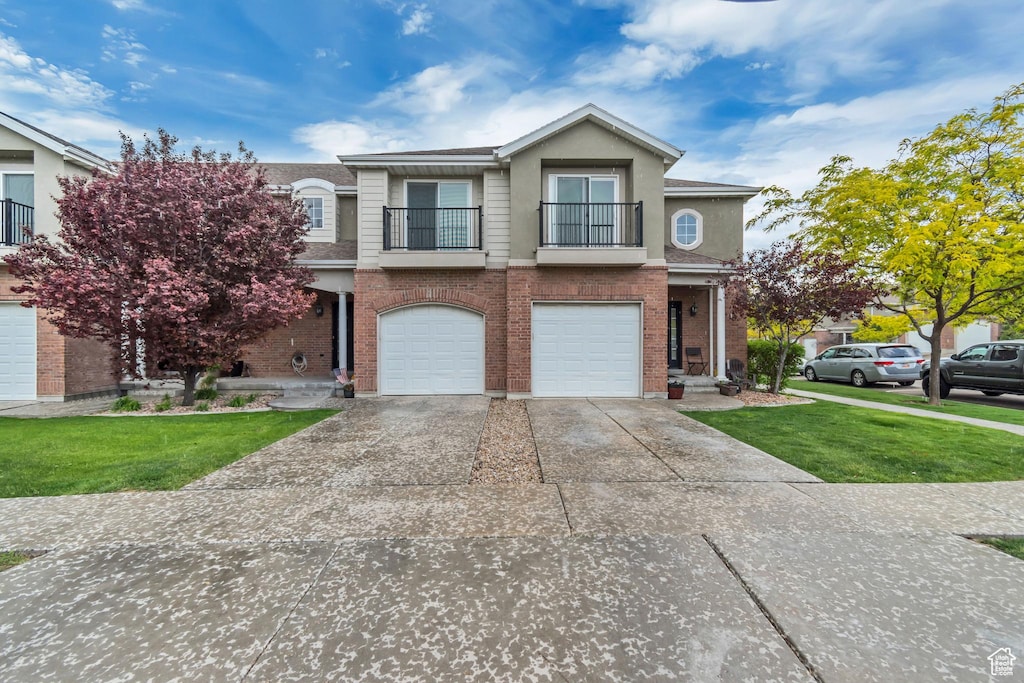 229 E July Ln, Saratoga Springs, UT 84045 - view of front of house featuring a balcony, driveway, a garage, and a front yard