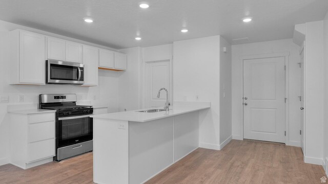 104 N Kelp Ln Unit 2310, Saratoga Springs, UT 84045 - kitchen featuring stainless steel appliances, a sink, light wood finished floors, white cabinetry, and light countertops
