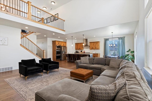 1046 W Seasons View Ct, Lehi, UT 84043 - living area with wood finished floors, a towering ceiling, stairway, a chandelier, and recessed lighting