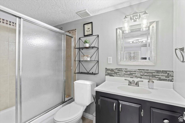 7265 N Ute Dr, Eagle Mountain, UT 84005 - full bath featuring vanity, toilet, decorative backsplash, bath / shower combo with glass door, and a textured ceiling