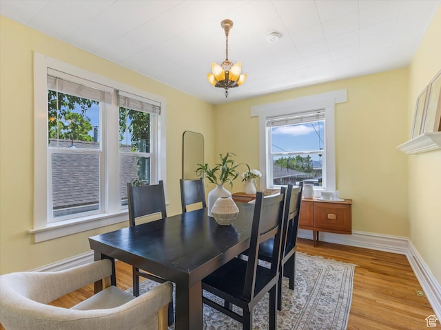 218 E Fifth Ave, Salt Lake City, UT 84103 - dining area featuring a chandelier, healthy amount of natural light, light wood-type flooring, and baseboards