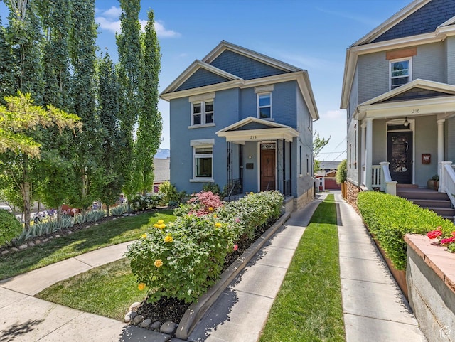 218 E Fifth Ave, Salt Lake City, UT 84103 - view of front of property with brick siding, covered porch, and a front yard