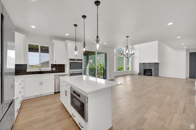 2279 E Ravine Rock Way, Draper, UT 84020 - kitchen featuring stainless steel appliances, a sink, decorative backsplash, light wood-style flooring, and a kitchen island