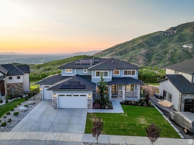 2279 E Ravine Rock Way, Draper, UT 84020 - view of front of house featuring solar panels, driveway, stone siding, a garage, and a mountain view