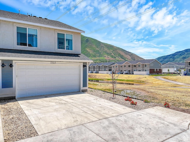 1323 S 3540 E, Spanish Fork, UT 84660 - view of front of home with a mountain view, stucco siding, an attached garage, a residential view, and driveway