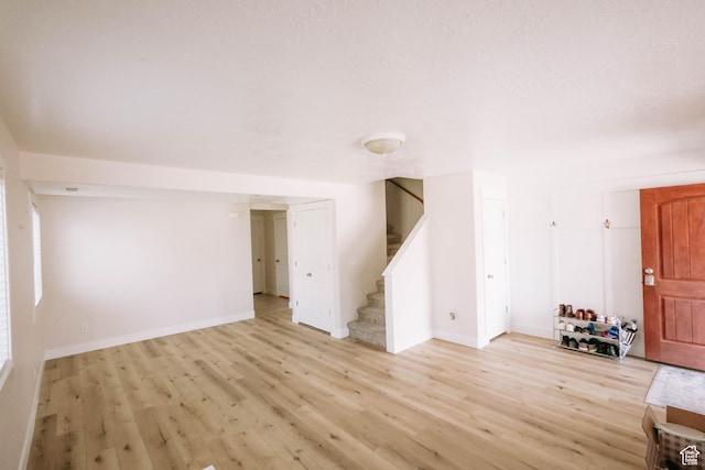 119 W 700 N, Vernal, UT 84078 - unfurnished living room featuring stairs, light wood-type flooring, and baseboards
