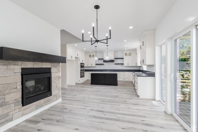 3616 N 600 E, North Ogden, UT 84414 - kitchen featuring a sink, dark countertops, light wood-style flooring, a chandelier, and white cabinetry