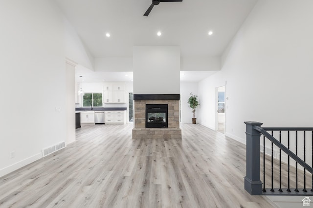 3616 N 600 E, North Ogden, UT 84414 - unfurnished living room with a ceiling fan, light wood-type flooring, recessed lighting, a stone fireplace, and baseboards