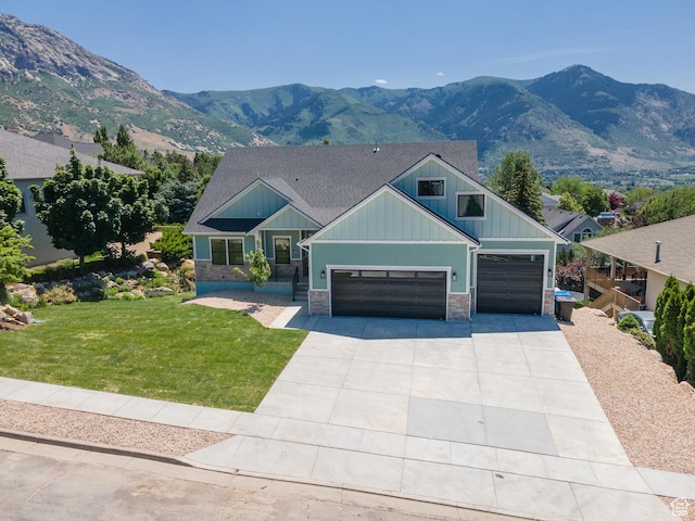 3616 N 600 E, North Ogden, UT 84414 - craftsman-style home featuring board and batten siding, a front yard, driveway, a mountain view, and stone siding