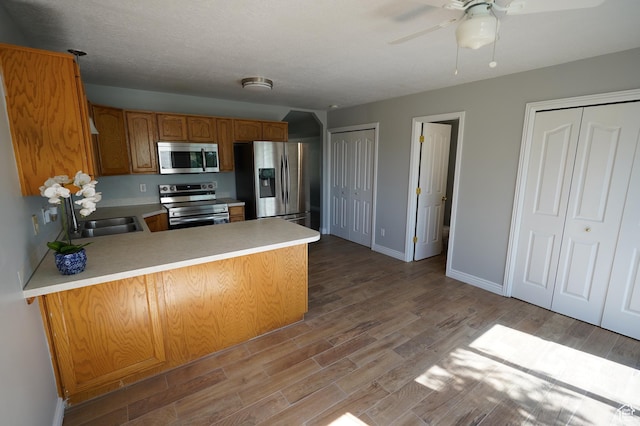 2881 N 450 E, North Ogden, UT 84414 - kitchen with appliances with stainless steel finishes, light countertops, a peninsula, a sink, and wood finished floors