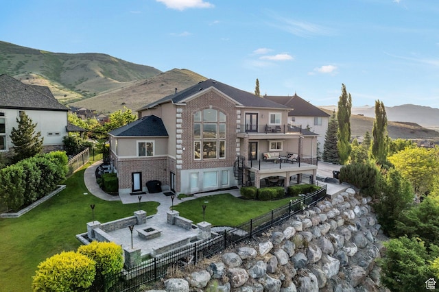 14709 S Cedar Knoll Cir, Herriman, UT 84096 - back of house with a balcony, brick siding, a patio area, and an outdoor fire pit