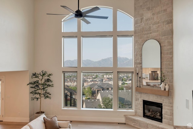 14709 S Cedar Knoll Cir, Herriman, UT 84096 - living room featuring a high ceiling, a ceiling fan, a mountain view, a fireplace, and wood finished floors