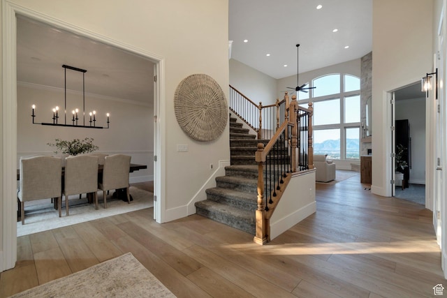 14709 S Cedar Knoll Cir, Herriman, UT 84096 - stairway with a high ceiling, a ceiling fan, wood-type flooring, baseboards, and a chandelier