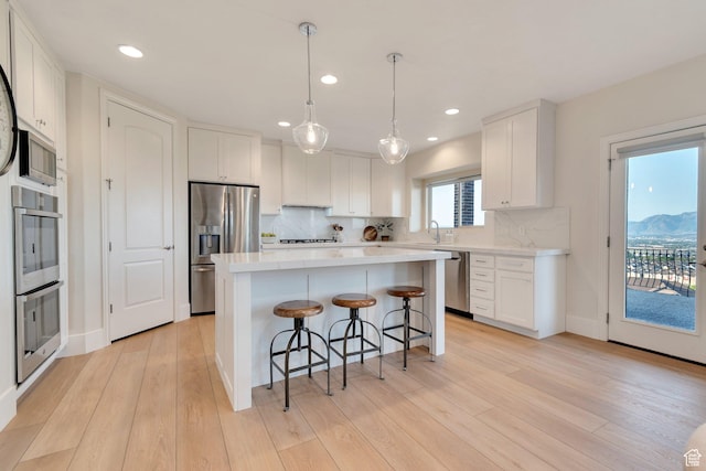 14709 S Cedar Knoll Cir, Herriman, UT 84096 - kitchen featuring appliances with stainless steel finishes, a breakfast bar, white cabinetry, a sink, and recessed lighting