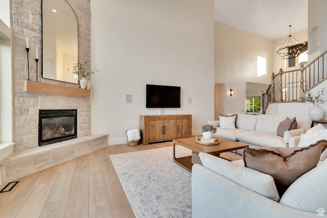 14709 S Cedar Knoll Cir, Herriman, UT 84096 - living room featuring a high ceiling, hardwood / wood-style flooring, stairs, baseboards, and a stone fireplace