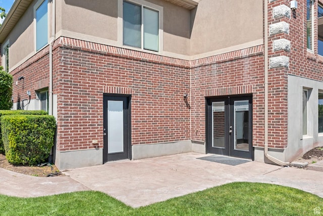 14709 S Cedar Knoll Cir, Herriman, UT 84096 - rear view of property featuring french doors, brick siding, a patio area, and stucco siding
