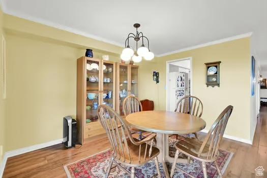 1785 29th St Unit 504, Ogden, UT 84403 - dining room with a chandelier, wood finished floors, crown molding, and baseboards
