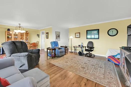 1785 29th St Unit 504, Ogden, UT 84403 - living area with a chandelier, wood finished floors, baseboards, and crown molding