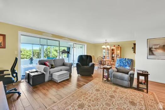 1785 29th St Unit 504, Ogden, UT 84403 - living room featuring wood finished floors and a chandelier