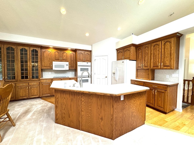 362 S Glen Cir E, Fruit Heights, UT 84037 - kitchen featuring white appliances, brown cabinets, light countertops, an island with sink, and recessed lighting