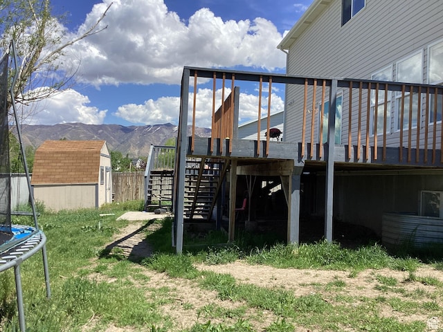 781 E Valley View Dr, Tooele, UT 84074 - view of yard with a trampoline, a deck with mountain view, and stairway