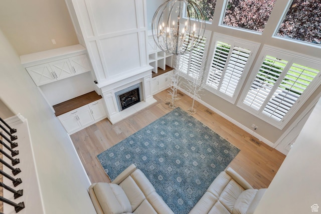 719 E Hampton Ct N, Alpine, UT 84004 - living room featuring wood finished floors, a chandelier, stairs, a premium fireplace, and a towering ceiling