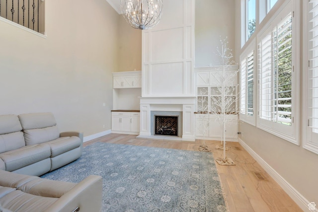 719 E Hampton Ct N, Alpine, UT 84004 - living room featuring a high ceiling, wood finished floors, a chandelier, healthy amount of natural light, and baseboards