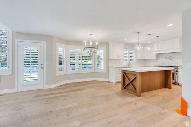 719 E Hampton Ct N, Alpine, UT 84004 - kitchen featuring stainless steel gas range, a chandelier, light countertops, tasteful backsplash, and white cabinetry