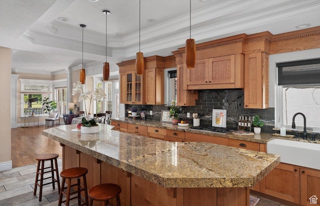 521 E 900 S, Salt Lake City, UT 84105 - kitchen featuring a sink, stainless steel gas stovetop, a kitchen island, ornamental molding, and backsplash