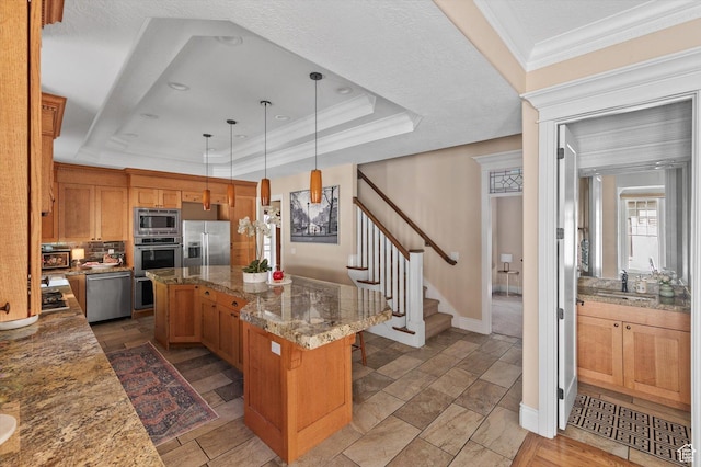 521 E 900 S, Salt Lake City, UT 84105 - kitchen featuring stainless steel appliances, a kitchen island, ornamental molding, a tray ceiling, and decorative light fixtures