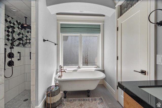 521 E 900 S, Salt Lake City, UT 84105 - full bathroom with a stall shower, a soaking tub, baseboards, vanity, and wood finished floors