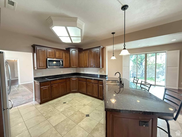 639 N 1550 E, Price, UT 84501 - kitchen with appliances with stainless steel finishes, a peninsula, a sink, a kitchen breakfast bar, and light tile patterned flooring