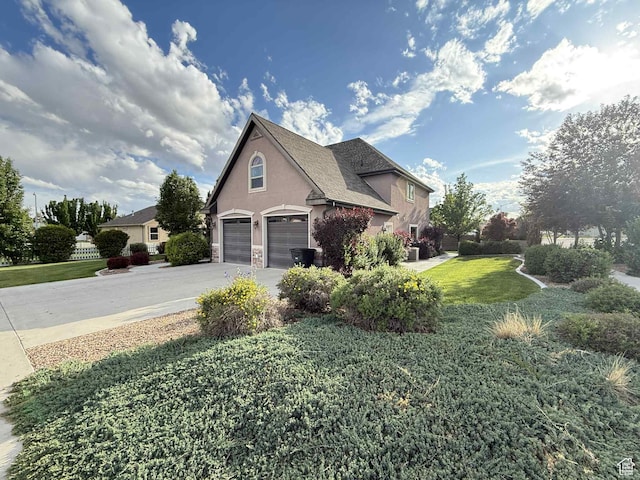 639 N 1550 E, Price, UT 84501 - view of home's exterior with a lawn, stucco siding, driveway, stone siding, and a garage