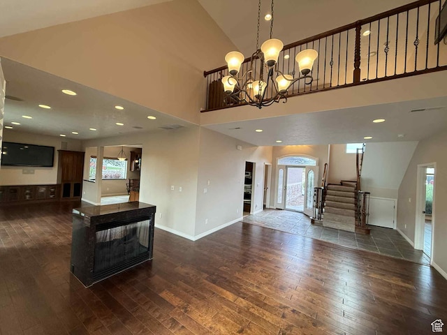 639 N 1550 E, Price, UT 84501 - unfurnished living room with dark wood finished floors, plenty of natural light, a high ceiling, and stairway