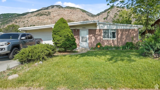 850 N Monroe Blvd E, Ogden, UT 84404 - view of front of property with a garage, a front lawn, a mountain view, and brick siding