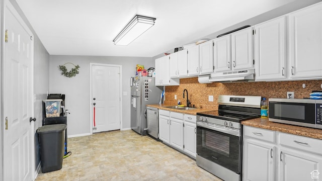 850 N Monroe Blvd E, Ogden, UT 84404 - kitchen with stainless steel appliances, a sink, under cabinet range hood, white cabinets, and decorative backsplash