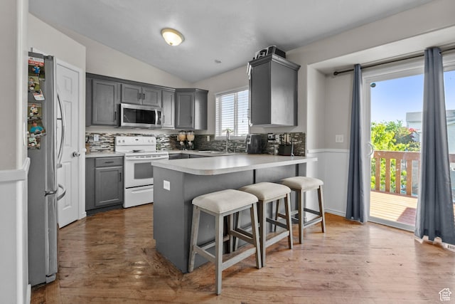 2456 W 1600 N, Clinton, UT 84015 - kitchen featuring stainless steel appliances, gray cabinetry, vaulted ceiling, a sink, and a breakfast bar area
