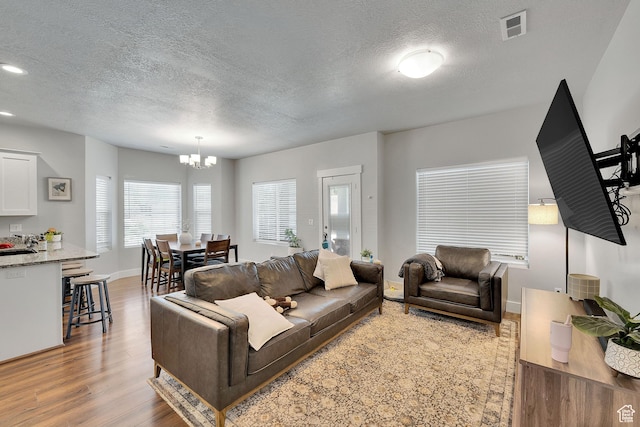 901 E 775 N, Layton, UT 84041 - living area with a chandelier, wood finished floors, a textured ceiling, baseboards, and recessed lighting