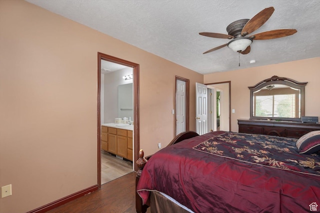3139 S Timeron Dr, West Valley City, UT 84128 - bedroom featuring wood finished floors, a sink, a textured ceiling, baseboards, and ensuite bathroom