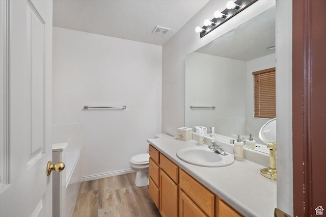 3139 S Timeron Dr, West Valley City, UT 84128 - full bath with vanity, a garden tub, wood finished floors, toilet, and baseboards