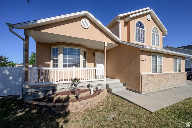 3139 S Timeron Dr, West Valley City, UT 84128 - view of front of house with stucco siding, covered porch, and brick siding